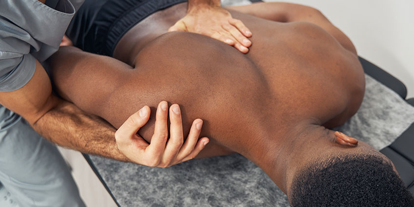 Pompano Beach auto accident forms for chiropractor adjusting patient's shoulder to relieve pain